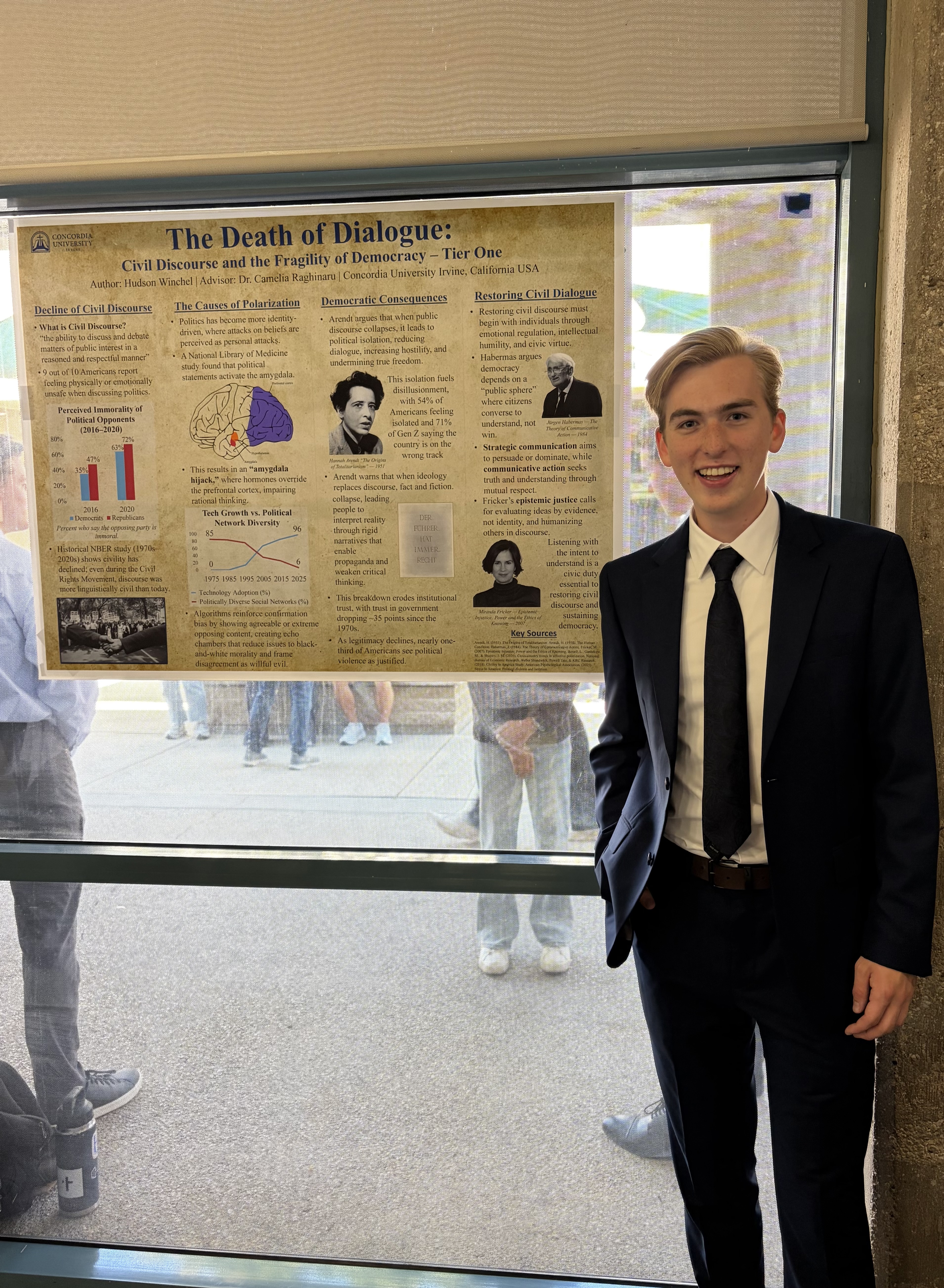 Hudson Winchel (junior) stands in front of the poster of his research project